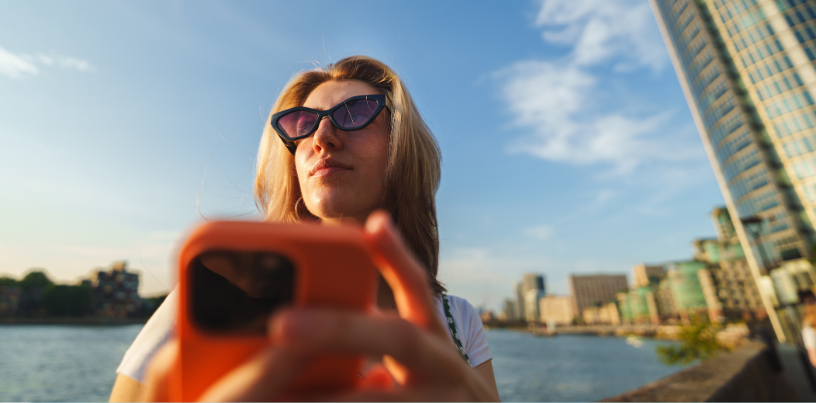 Jeune touriste utilisant une application de traduction pour communiquer avec la population locale durant son voyage. Adobe Stock.